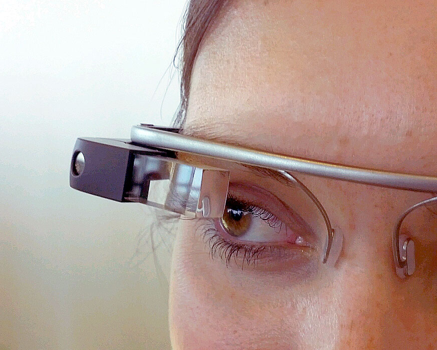 Close-up do rosto de uma pessoa usando óculos inteligentes com uma pequena tela transparente sobre o olho direito.