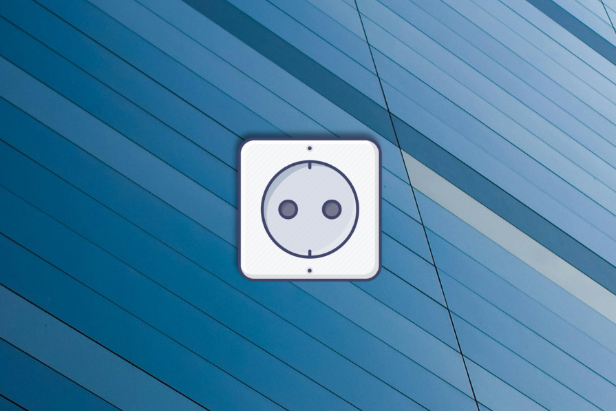 Tomada elétrica branca em forma de rosto sorridente montada em uma parede azul com listras diagonais claras e escuras.