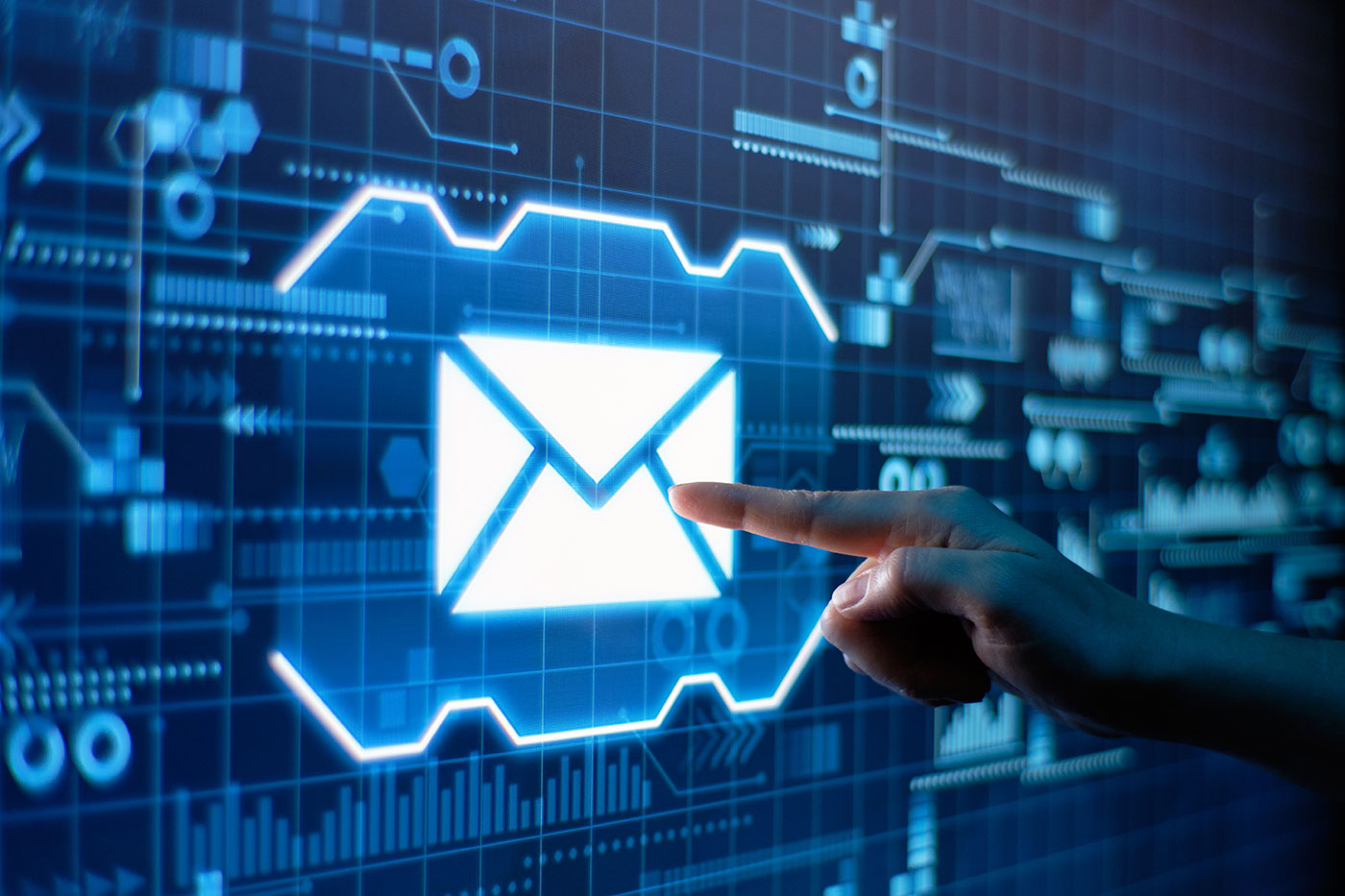 Mão apontando para ícone de e-mail iluminado em tela de interface digital azul com gráficos e diagramas tecnológicos ao fundo.