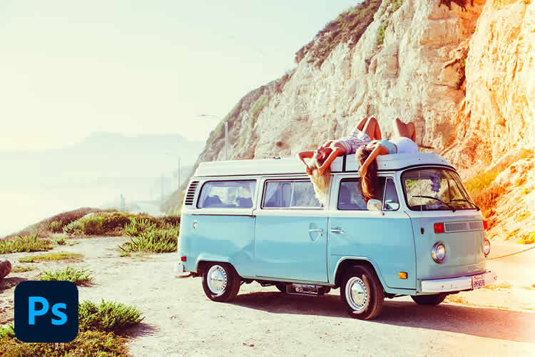 Casal relaxa no teto de uma van azul estilo vintage estacionada ao lado de uma falésia com vista para o oceano ao pôr do sol.