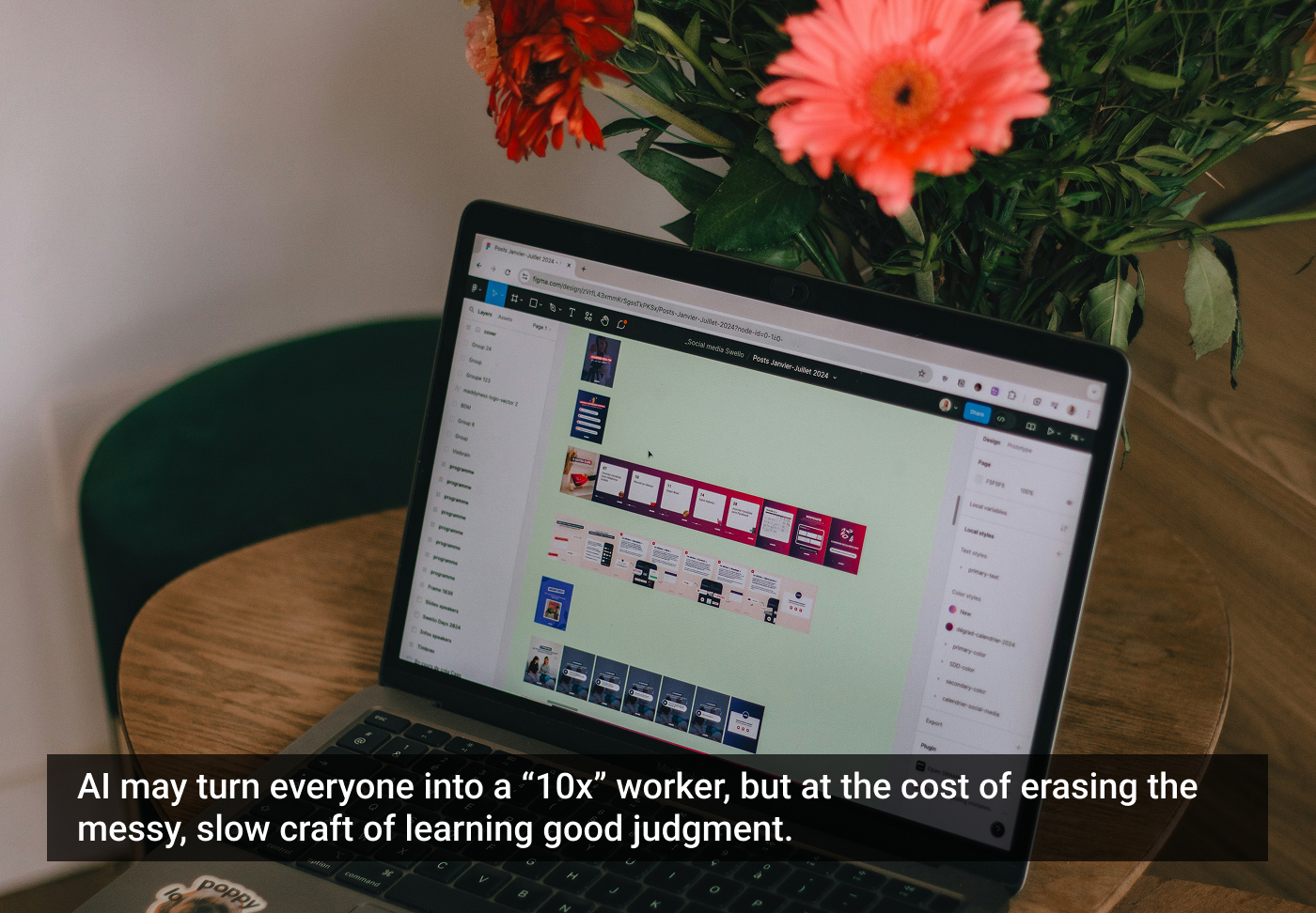 Laptop sobre uma mesa com tela mostrando um layout de website. Ao lado, um vaso com flores laranjas vivas. Ambiente de trabalho caseiro e aconchegante.